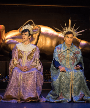 Two men in sequined robes sit on stage for the play Mankind for TRW Plays