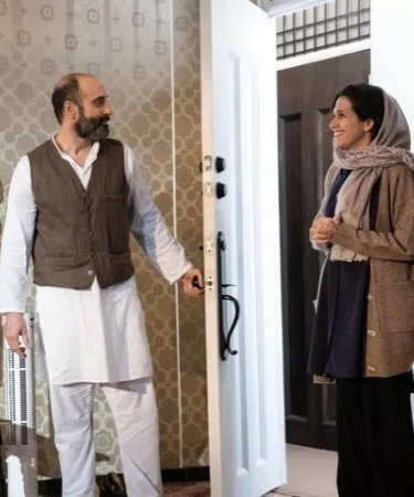 A woman and a man converse while he invites her in to his home from the play "Selling Kabul" for TRW Plays